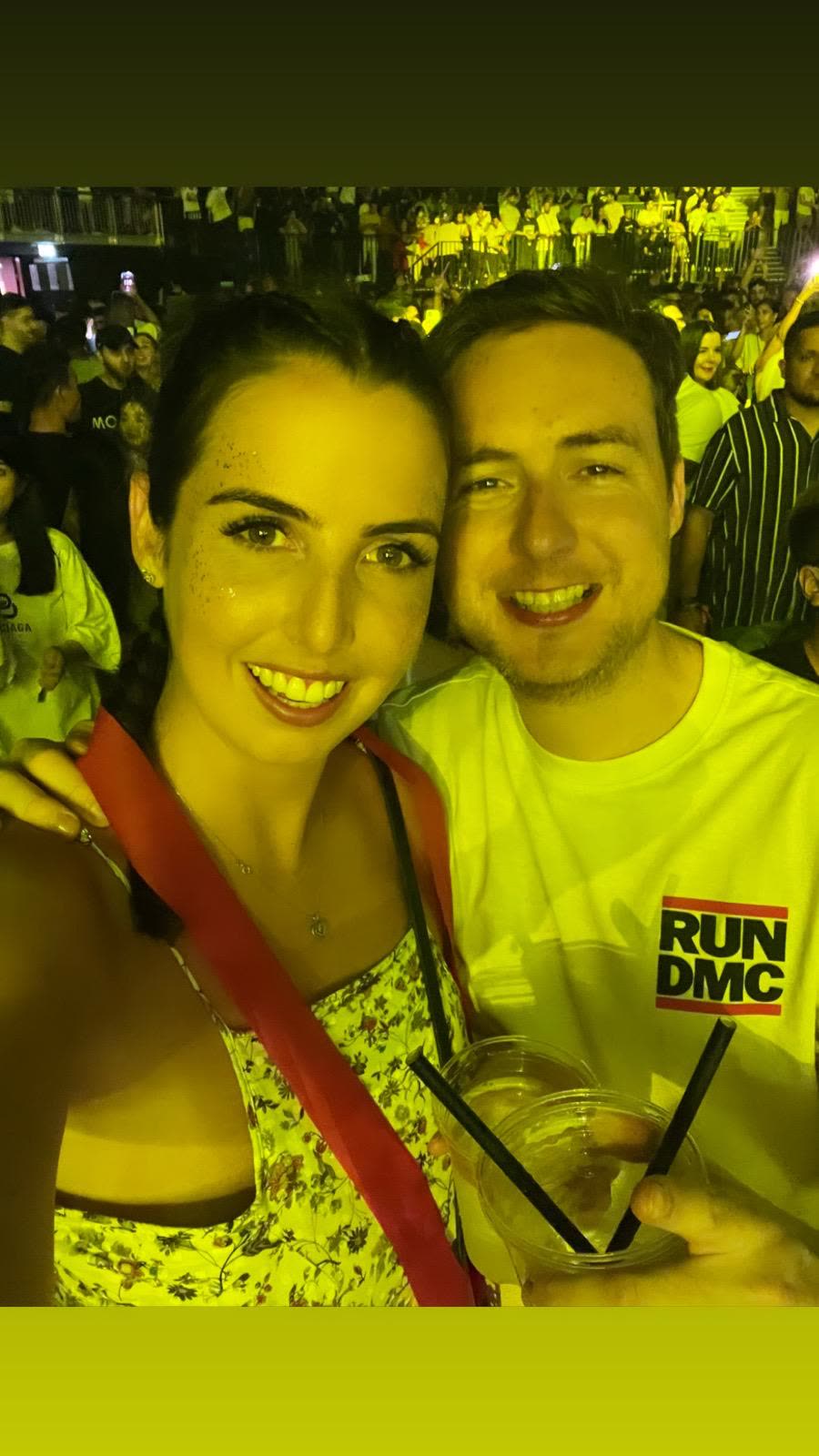 Grinning at a gig under yellow light
